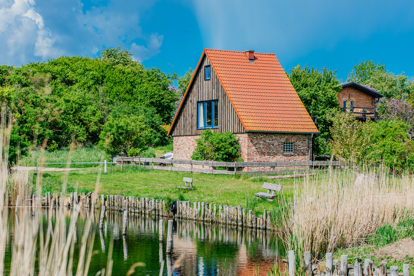 Naturhafen Stolpe in Mecklenburg-Vorpommern mit rotem Haus, Schilf und Wasser.