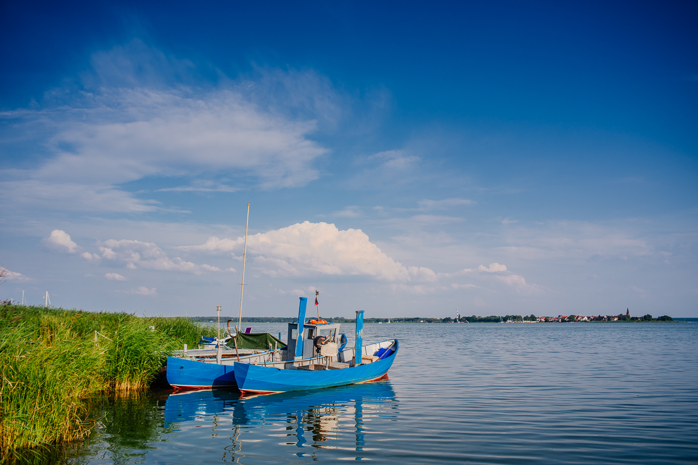 Blaues Fischerboot bei Altwarp am Stettiner Haff mit Blick in Richtung Neuwarp.